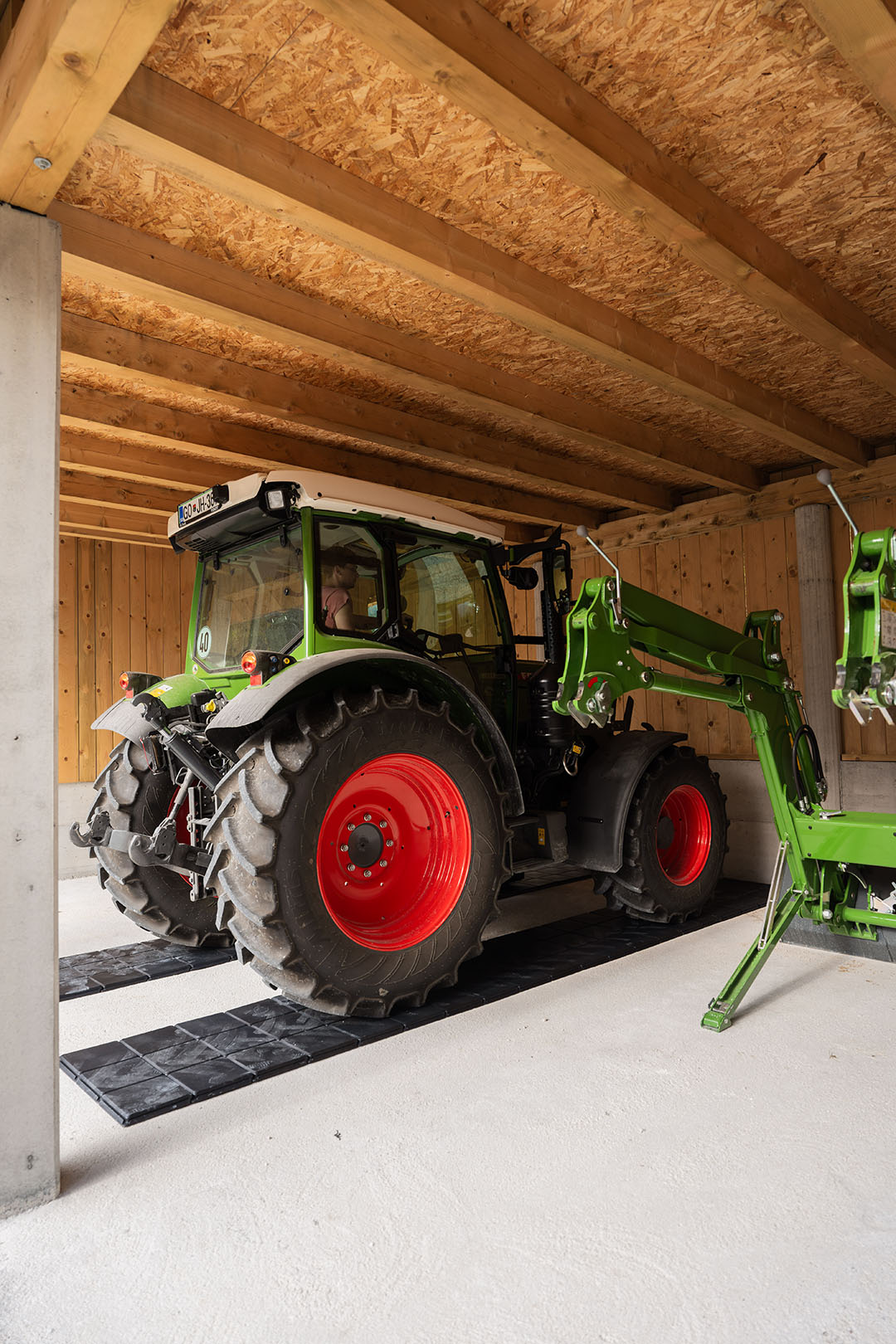 Traktor Fendt parkiran v garaži na pohodne plošče, ki razporedijo težo vozila
